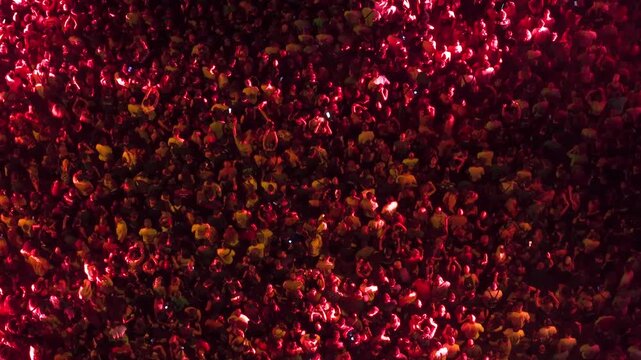 High angle aerial view of massive crowd dancing at live music festival concert