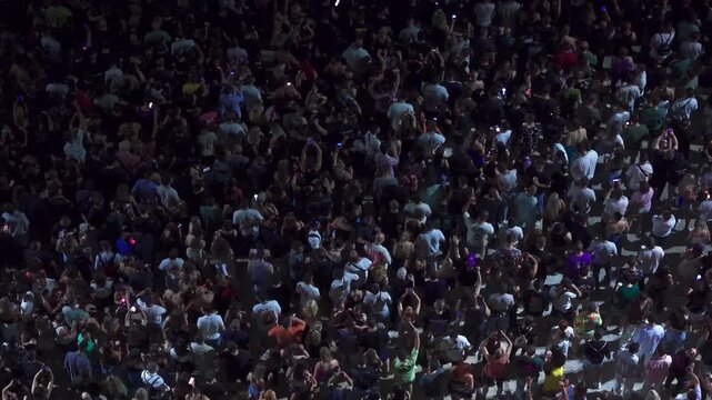High angle aerial view of massive crowd dancing at live music festival concert