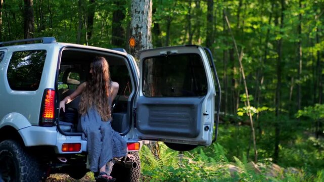 Cinematic moment of a woman in an SUV in the forest reacting with surprise after something falls, capturing authentic emotion, travel lifestyle, and unexpected outdoor experiences.
