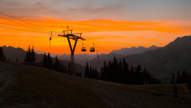 Summer sunset or sundowner view with silhouettes of a cable car mast and gondulas at Mount Asitz, Leogang, Zell am See, Pinzgau, Salzburg, Austria