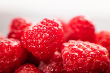 Cluster of bright red raspberries, fresh fruit display, juicy berry assortment, vibrant produce presentation, close-up still life © ketrin