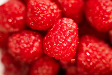 Cluster of bright red raspberries, fresh fruit display, juicy berry assortment, vibrant produce presentation, close-up still life © ketrin