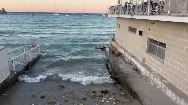 a stretch of beach on the Otranto waterfront bordered by a restaurant building built right on the sea