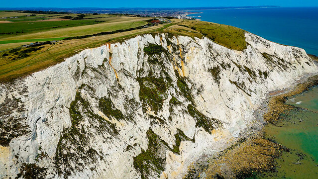 Aerial drone view of the dramatic white chalk cliffs at Beachy Head near Eastbourne, England, showcasing the rugged coastline, cliff formations 