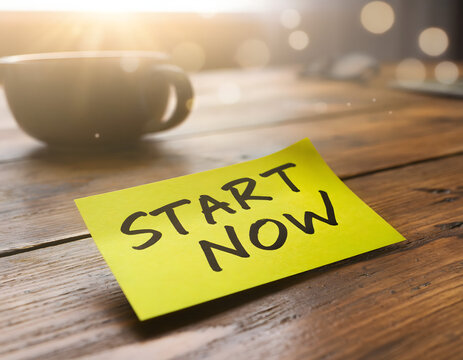 Nota adhesiva amarilla con texto Start Now en escritorio