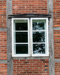 Fototapeta premium White wooden window on traditional red brick timber frame wall