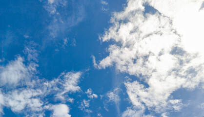 Vivid blue sky with bright white cumulus clouds creating a dramatic natural cloudscape. Fresh summer weather background with copy space, ideal for nature, travel and environmental themes  © Anna_Li