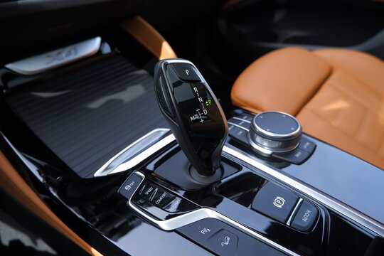Modern luxury car gear shift lever inside a premium vehicle with tan leather interior seats
