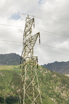 Guttannen, Switzerland. High-voltage electricity transmission tower against alpine mountains in the Bernese Oberland