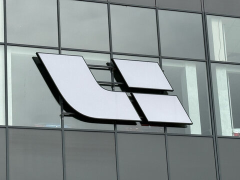 Modern glass facade of a Li Auto (Lixiang) official car dealership showroom with the brand logo on the window. Premium Chinese electric vehicle dealership building.