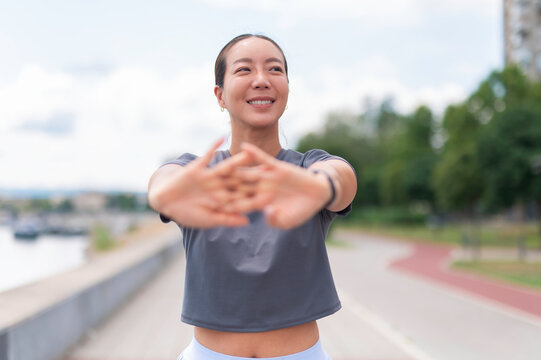 Asian woman stretching outdoors enjoying fitness workout