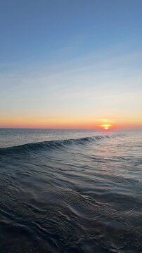 Vertical video. Gliding Above Sunset Surf at Nyang Nyang Beach, Golden Reflections Across Ocean Foam And Dramatic Bali Coastline