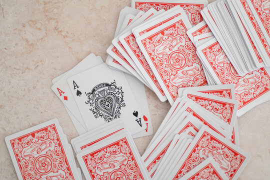 Winning hand of four aces arranged over a deck of playing cards. Poker success, casino gaming, card strategy and tabletop entertainment with a clean marble background.