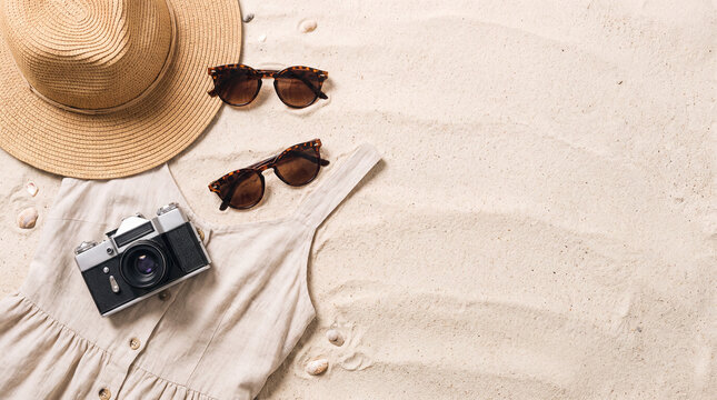 Summer vacation items on sandy beach background