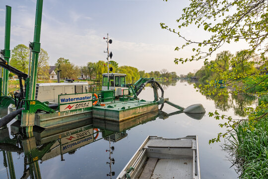 Green Watermaster Dredger Boat Performing River Dredging Near Riverside Village With Calm Reflections, Vinkovci, Croatia