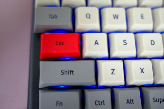 Red Esc key on gray computer keyboard, close-up. Escape, Exit and Opt out concept