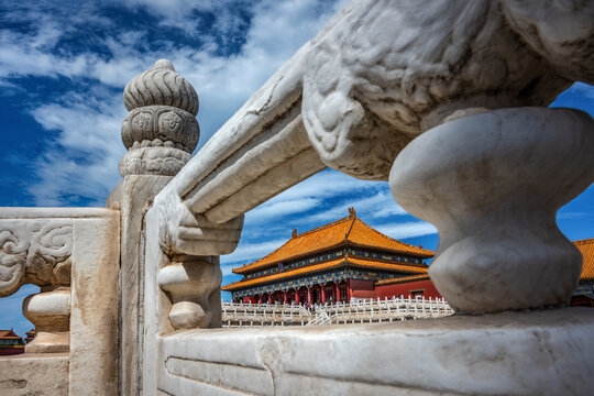Traditional Chinese palace framed through white marble balustrade in the Forbidden City with blue sky, Beijing, China