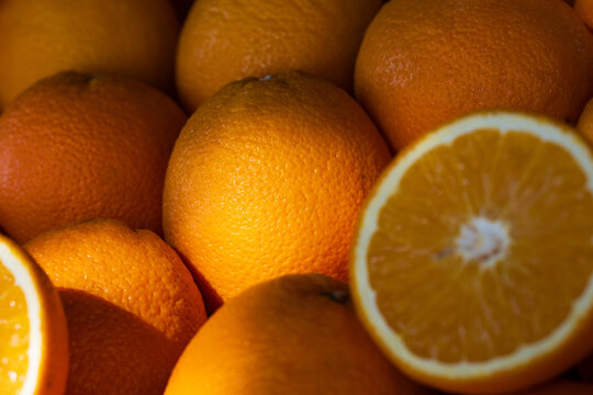 Ripening oranges displaying textured skin and a vibrant cross-section