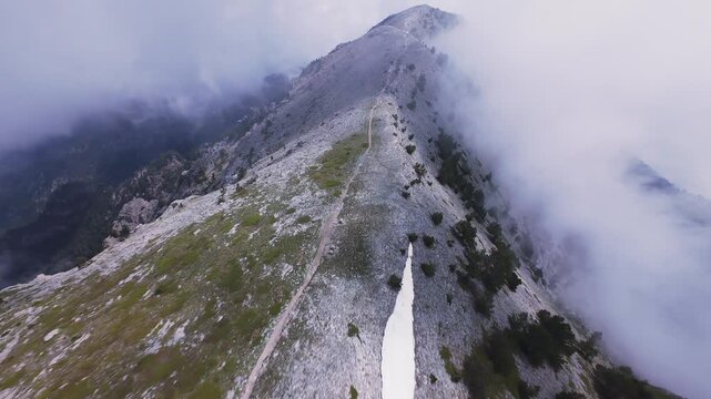 Dynamic FPV drone shot diving along sharp crest of Mount Olympus Greece