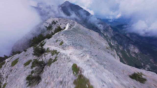 Dynamic FPV drone shot diving along sharp crest of Mount Olympus Greece