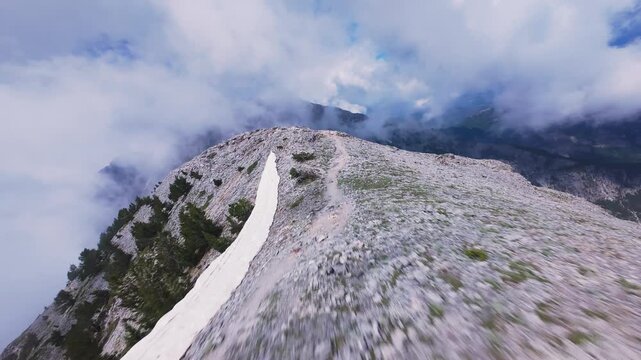 Dynamic FPV drone shot diving along sharp crest of Mount Olympus Greece