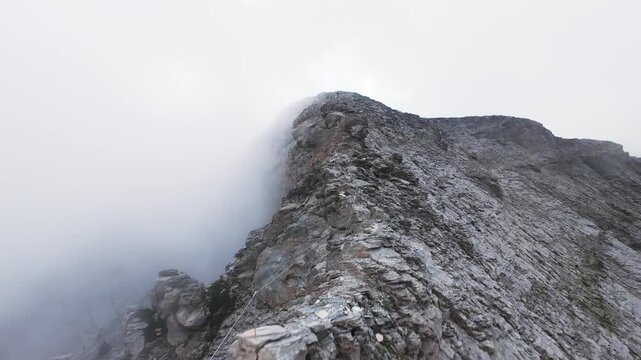 Dynamic FPV drone shot climbing along sharp crest of Mount Olympus Greece