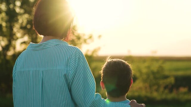 woman mother hugs boy son sunset, woman hugs child kid in nature, people outdoors, maternal care children love, happy family, gentle affectionate contact, authentic candid moment, horizon and sky