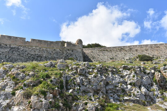 Ancient stone fortress walls with green vegetation, Crete