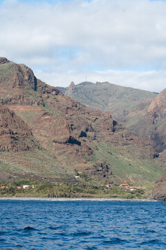 Terraced valleys and rugged volcanic mountains above a coastal settlement on La Gomera Canary Islands Spain