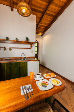Healthy Breakfast Spread on Wooden Table in Cozy Cabin Kitchenette with Scrambled Eggs, Fruit, and Coffee