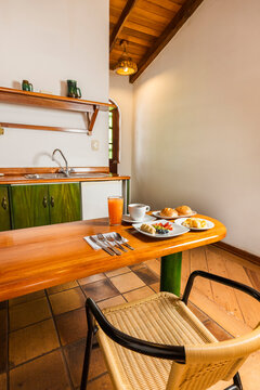 Healthy Breakfast Spread on Wooden Table in Cozy Cabin Kitchenette with Scrambled Eggs, Fruit, and Coffee