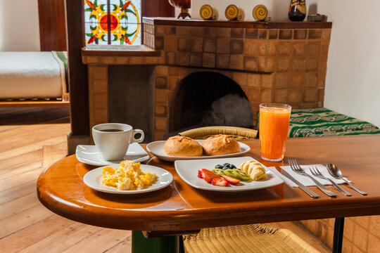 Healthy Breakfast Spread on Wooden Table in Cozy Cabin Kitchenette with Scrambled Eggs, Fruit, and Coffee