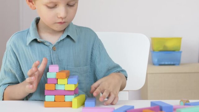 Child arranges wooden blocks in groups showing early classification and pattern recognition skill. Reggio approach and Montessori hands on learning with natural material concept. 