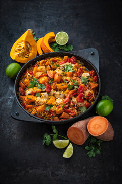 Slow cooked casserole dish  healthy yummy spicy Italian one-pan role stew vegetable pumpkin, sweet potato, chicken and rice served as close-up in a design pot