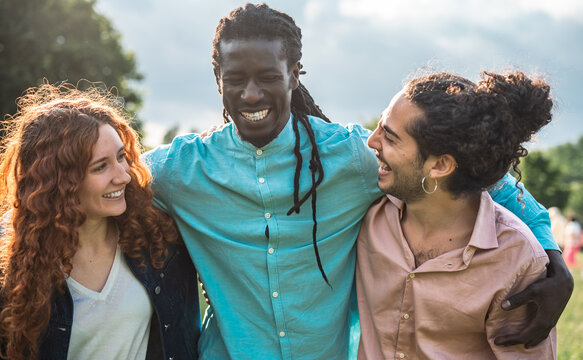 Close-up of Three Diverse Friends Embracing at Sunset