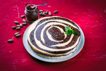 Fototapeta premium Artisan homemade baked zebra black-white cheesecake pie with dark chocolate served as close-up on a design plate