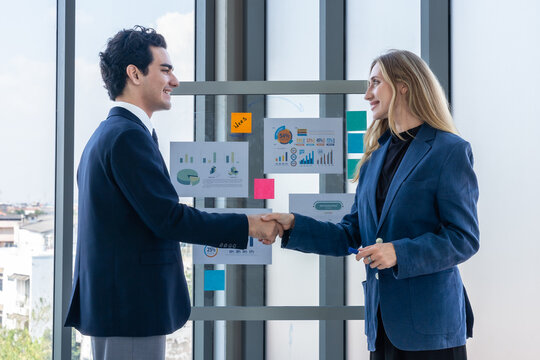 Two businessman and businesswoman partners  in suits smiling standing Talking Discussing presenting financial graph Concept on flip chart board  business expressed embolden and successful concept.