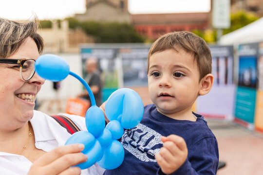 Mother and child enjoying a blue balloon animal
