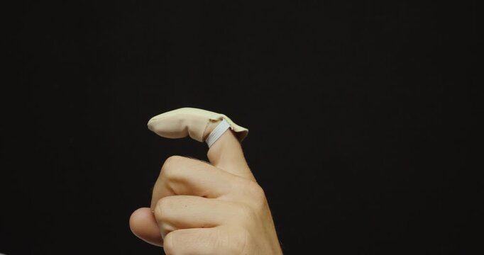 Close-up of a hand wearing a protective finger cot for finger protection, hygiene, medical care, or precision work.
