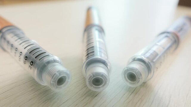 Three medical injection pens arranged close up on table