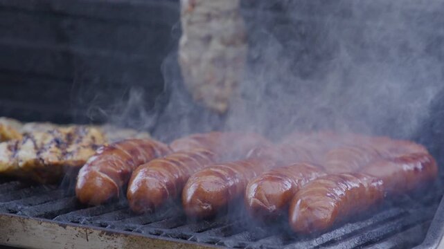 Man with barbeque roast meat sausage outdoor. Grilling and barbecue. BBQ and grill. Preparing beef sausage meat in barbecue. Chef barbecuing sausage. Backyard BBQ. Man cook steak meat