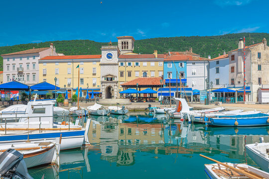 Historic harbor of Cres town on Cres Island, Croatia. Colorful Venetian buildings, traditional fishing boats and Adriatic waterfront in the Kvarner Bay on a sunny summer day in Cres Island of Croatia.
