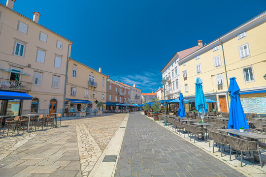 Main square of Cres town on Cres Island, Croatia. Historic waterfront square with cafes, pastel buildings and Mediterranean architecture on a sunny summer day. Kvarner Gulf of Cres Island in Croatia.