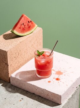 Refreshing watermelon drink on minimalist concrete blocks