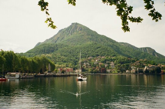 Sailboat on Lake Como with green mountain, Lecco, Italy
