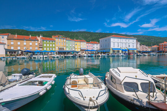 Historic harbor of Cres town on Cres Island, Croatia. Colorful Venetian buildings, traditional fishing boats and Adriatic waterfront in the Kvarner Bay on a sunny summer day in Cres Island of Croatia.