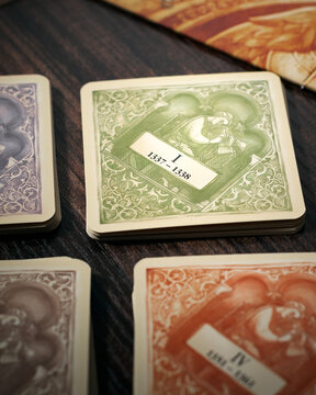 Portrait macro product photography of A World Without End event cards showing date ranges designed by Michael Rieneck and Stefan Stadler
