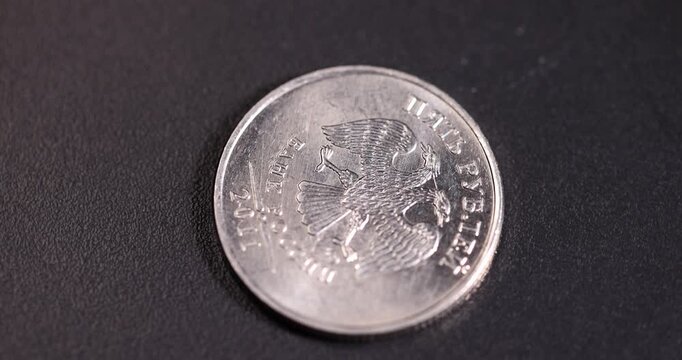 Russian coins of a small denomination of two rubles on a black surface, official money worth 2 rubles of the Russian Federation lies on a black surface 