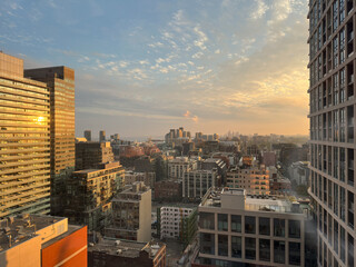 Obraz premium Toronto city skyline is displaying a mix of modern and historical architecture, with office towers and residential buildings in the evening sunset