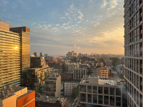 Toronto city skyline is displaying a mix of modern and historical architecture, with office towers and residential buildings in the evening sunset